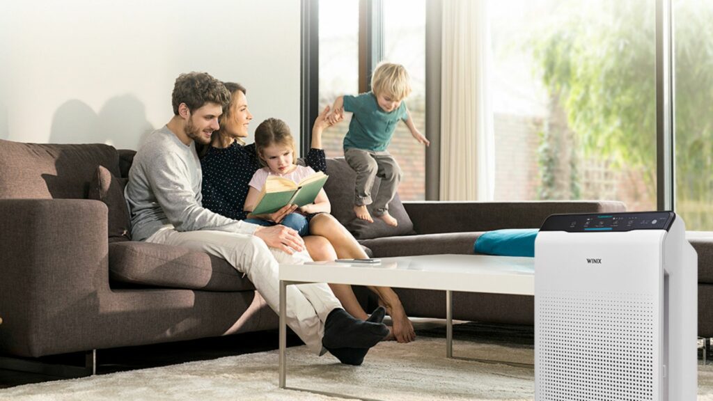 Rodzina pezeglądająca książkę w salonie obok oczyszczacza powietrza Winix Zero